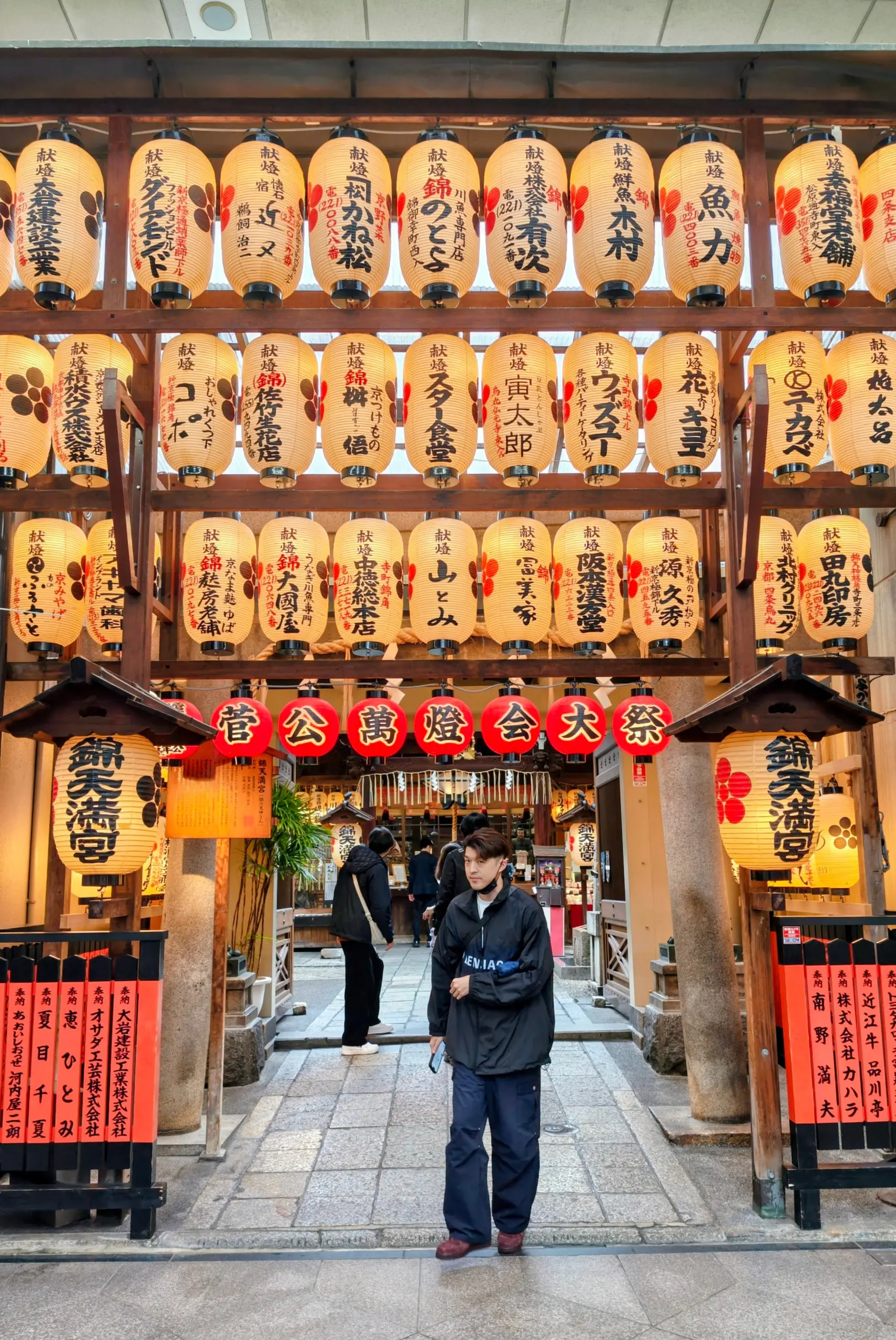 Čtyři lidé se usmívají na společné selfie před vchodem do japonské nudlové restaurace.