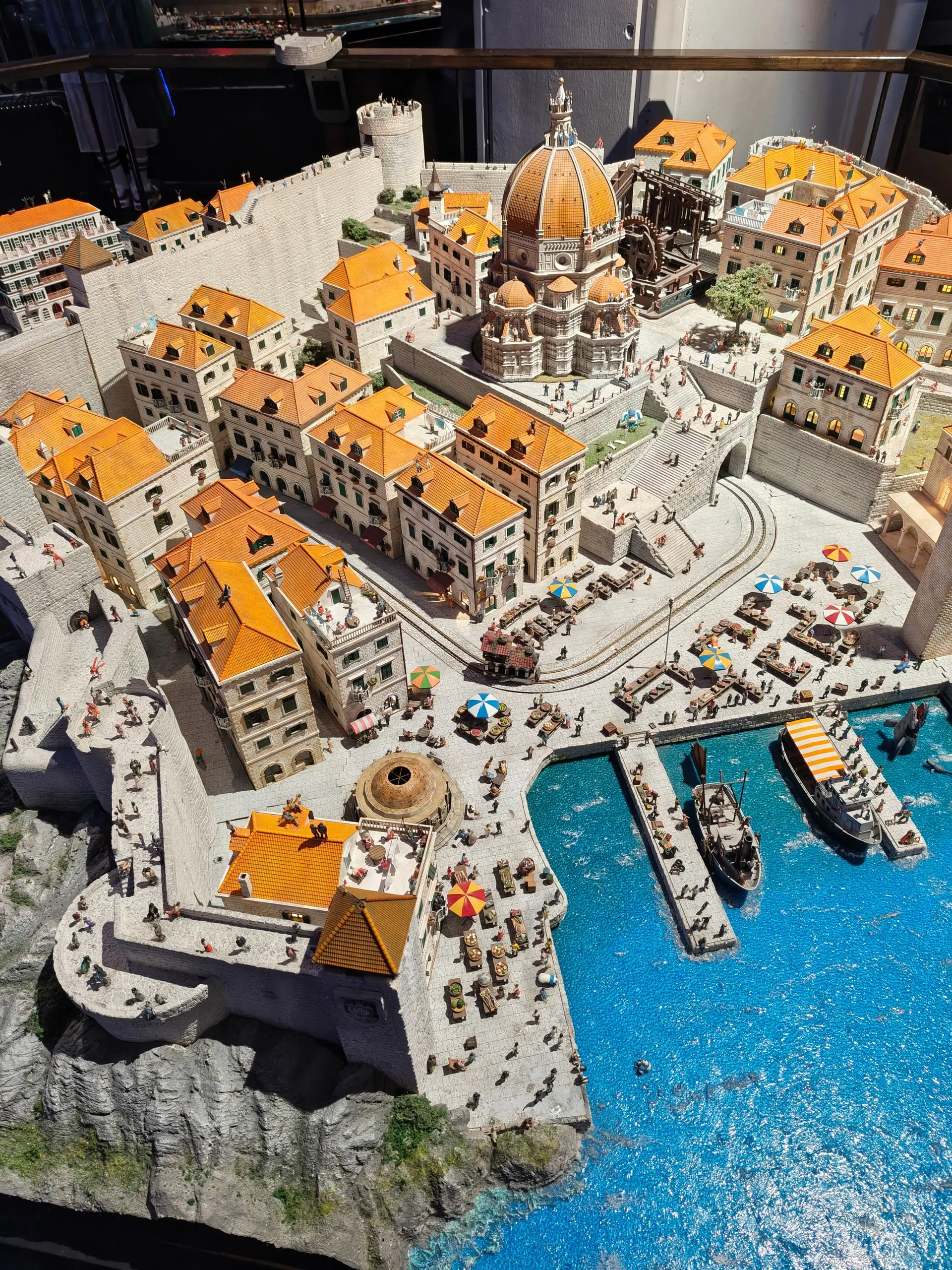 Detailní miniaturní model středomořského přístavního města s katedrálou na výstavě Small Worlds.